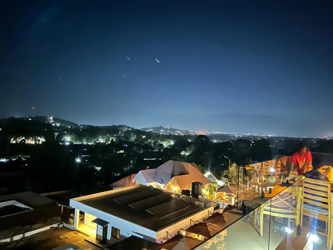 Arusha at night from a rooftop terrace, the lights of the town spread out below